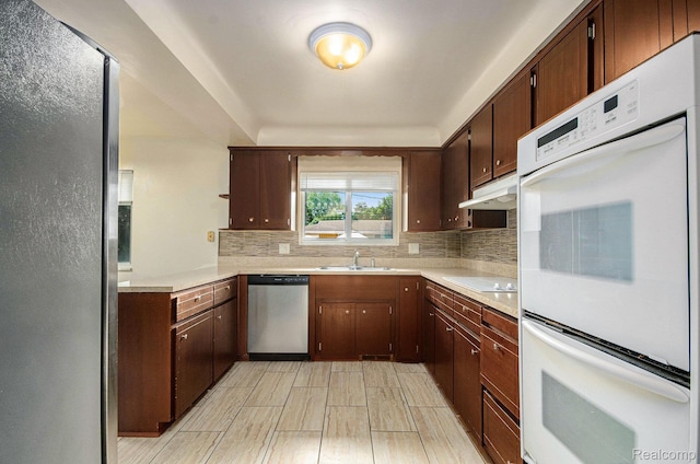 18319 Greenwald Dr, Southfield, MI 48075 - kitchen with stainless steel appliances, under cabinet range hood, light countertops, backsplash, and dark brown cabinetry
