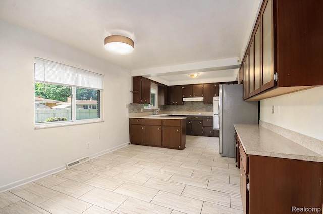 18319 Greenwald Dr, Southfield, MI 48075 - kitchen with freestanding refrigerator, light countertops, dark brown cabinets, backsplash, and under cabinet range hood