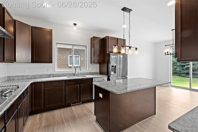 30493 Bradmore Rd, Warren, MI 48092 - kitchen with appliances with stainless steel finishes, light wood-type flooring, dark brown cabinets, a kitchen island, and light stone countertops