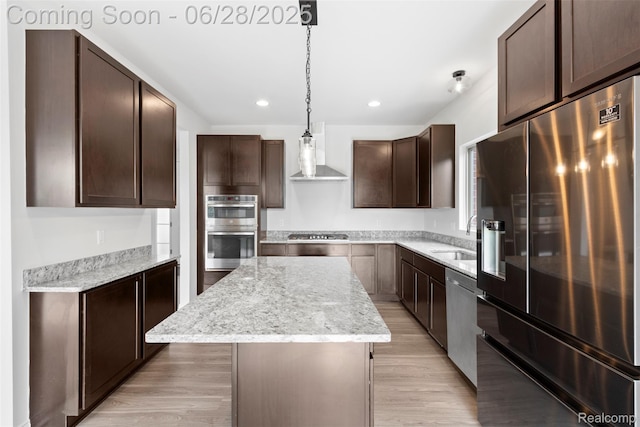 30493 Bradmore Rd, Warren, MI 48092 - kitchen with appliances with stainless steel finishes, wall chimney exhaust hood, a kitchen island, dark brown cabinetry, and light wood-type flooring