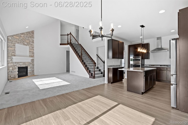 30493 Bradmore Rd, Warren, MI 48092 - kitchen with wall chimney range hood, a chandelier, dark brown cabinetry, stainless steel appliances, and a center island