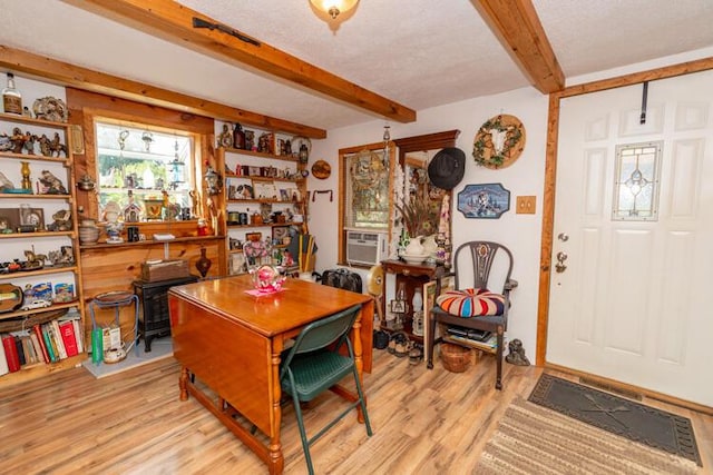 1213 Thomson Rd, Niles, MI 49120 - dining space with beamed ceiling, light wood-style flooring, cooling unit, and a wood stove