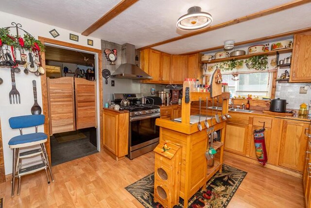 1213 Thomson Rd, Niles, MI 49120 - kitchen featuring gas range, wall chimney range hood, open shelves, light wood-style floors, and beamed ceiling