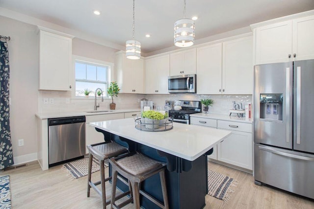 5589 Paxton Ct, Portage, MI 49024 - kitchen featuring stainless steel appliances, light countertops, light wood-type flooring, white cabinetry, and tasteful backsplash