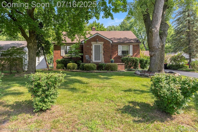 21280 Mada Ave, Southfield, MI 48075 - view of front facade with brick siding, a front yard, and a chimney