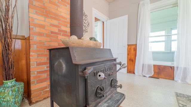 18216 S Schwark Rd, Three Oaks, MI 49128 - detailed view of a wood stove, speckle patterned floor, and a wainscoted wall