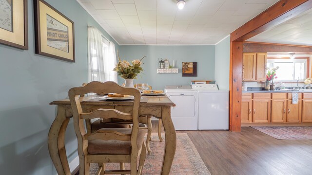 18216 S Schwark Rd, Three Oaks, MI 49128 - dining area featuring washing machine and dryer, light wood-type flooring, and crown molding