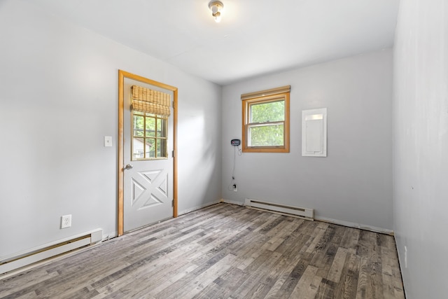 4382 S Vandervoight, Traverse City, MI 49696 - spare room featuring a baseboard heating unit and wood finished floors