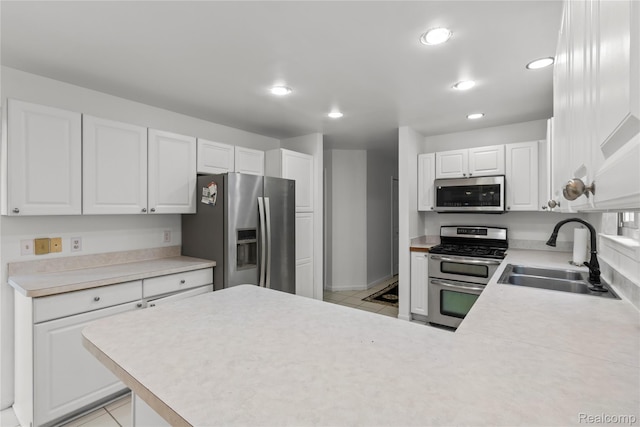 25893 Golf Pointe Dr, Southfield, MI 48075 - kitchen with stainless steel appliances, light tile patterned floors, recessed lighting, a peninsula, and white cabinets