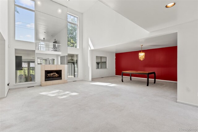 25893 Golf Pointe Dr, Southfield, MI 48075 - unfurnished living room with carpet flooring, a towering ceiling, and a tile fireplace