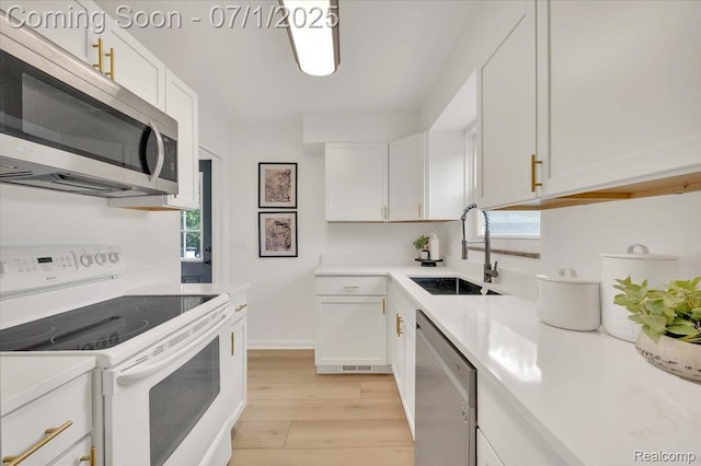 2190 Crescent Lake Rd, Holly, MI 48329 - kitchen with appliances with stainless steel finishes, white cabinets, light wood-type flooring, and light countertops
