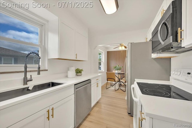 2190 Crescent Lake Rd, Holly, MI 48329 - kitchen featuring stainless steel appliances, light wood finished floors, white cabinets, a ceiling fan, and light countertops