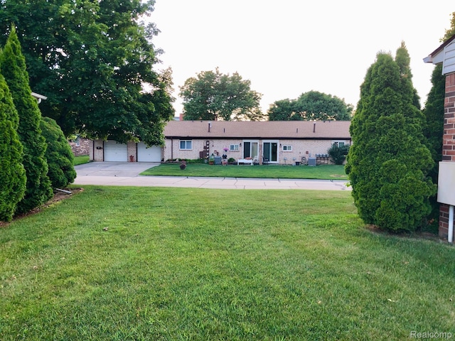 8681 Tucson Ct, Warren, MI 48093 - view of front of house featuring a front lawn, a chimney, brick siding, and a garage