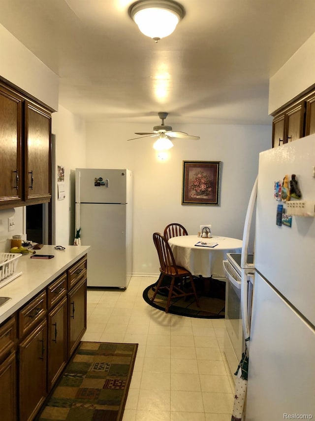 8681 Tucson Ct, Warren, MI 48093 - kitchen featuring white appliances, ceiling fan, dark brown cabinets, light countertops, and light tile patterned floors