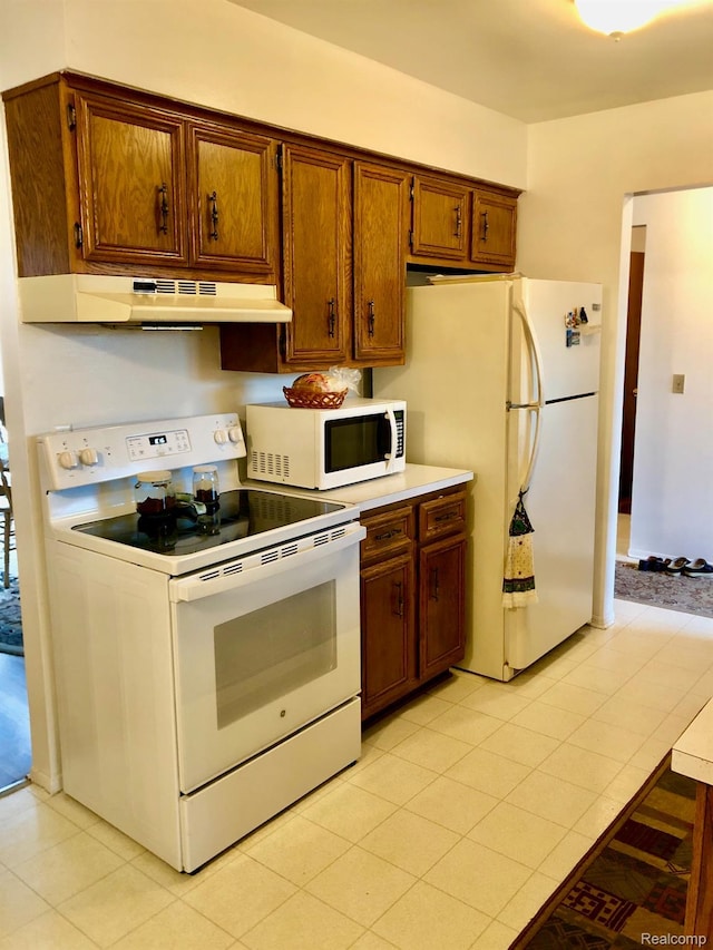 8681 Tucson Ct, Warren, MI 48093 - kitchen featuring white appliances, under cabinet range hood, light countertops, brown cabinets, and light tile patterned flooring