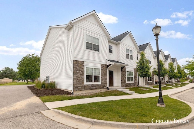 611 Bedford Falls Dr, Sparta, MI 49345 - multi unit property with stone siding, a front lawn, and a residential view