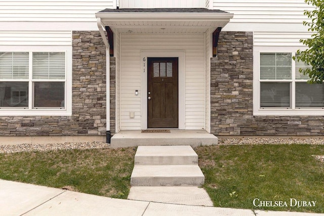 611 Bedford Falls Dr, Sparta, MI 49345 - view of exterior entry featuring stone siding and a lawn