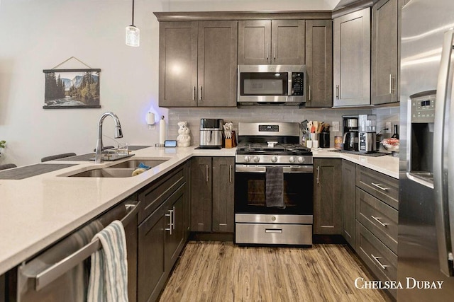 611 Bedford Falls Dr, Sparta, MI 49345 - kitchen with appliances with stainless steel finishes, light countertops, light wood-style floors, dark brown cabinets, and backsplash