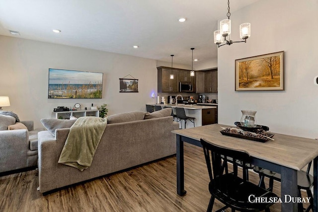611 Bedford Falls Dr, Sparta, MI 49345 - living room featuring dark wood-style floors, a chandelier, and recessed lighting