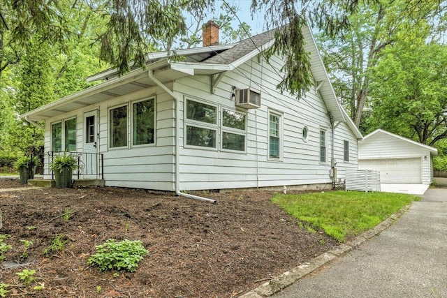 46210 Perkins Blvd, New Buffalo, MI 49117 - view of side of property featuring a chimney, an outbuilding, a detached garage, and a wall mounted AC