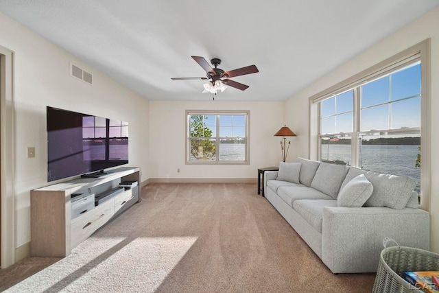 4078 Woodland Ave, Manitou Beach, MI 49253 - living area featuring light carpet, a ceiling fan, and a water view