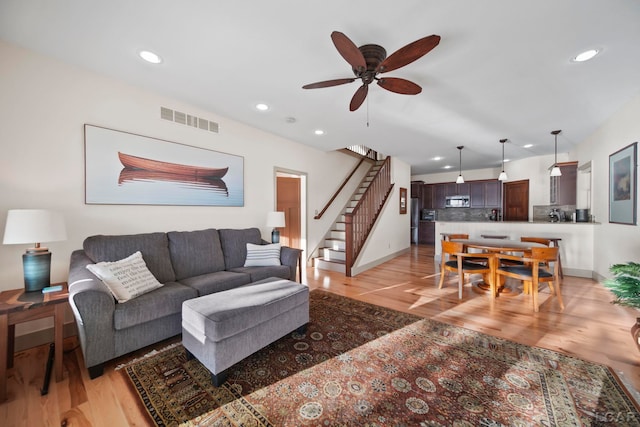 4078 Woodland Ave, Manitou Beach, MI 49253 - living room with light wood-type flooring, ceiling fan, stairway, and recessed lighting