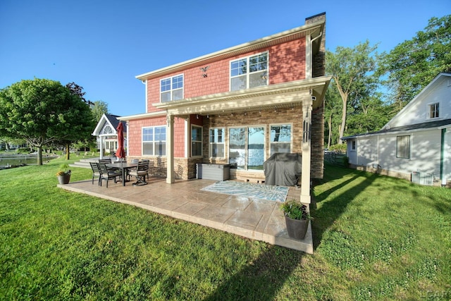 4078 Woodland Ave, Manitou Beach, MI 49253 - rear view of property featuring a patio, a lawn, and stone siding