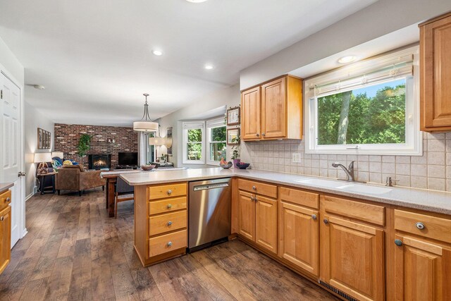 2211 Skyline Dr NW, Grand Rapids, MI 49504 - kitchen featuring stainless steel dishwasher, open floor plan, a peninsula, a brick fireplace, and dark wood-style floors