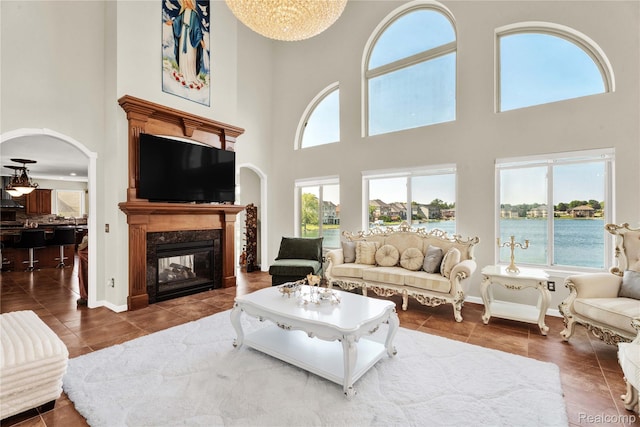 4303 S Lake Ln, Shelby Twp, MI 48316 - tiled living area with a high ceiling, healthy amount of natural light, a premium fireplace, and arched walkways