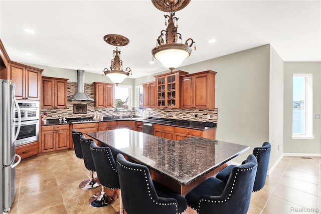 4303 S Lake Ln, Shelby Twp, MI 48316 - kitchen with wall chimney range hood, appliances with stainless steel finishes, brown cabinetry, decorative backsplash, and recessed lighting