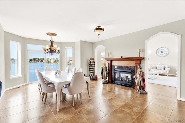 4303 S Lake Ln, Shelby Twp, MI 48316 - dining area featuring arched walkways, a chandelier, tile patterned floors, and a premium fireplace