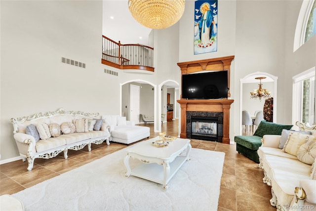 4303 S Lake Ln, Shelby Twp, MI 48316 - living room with a high ceiling, a chandelier, a premium fireplace, tile patterned flooring, and arched walkways