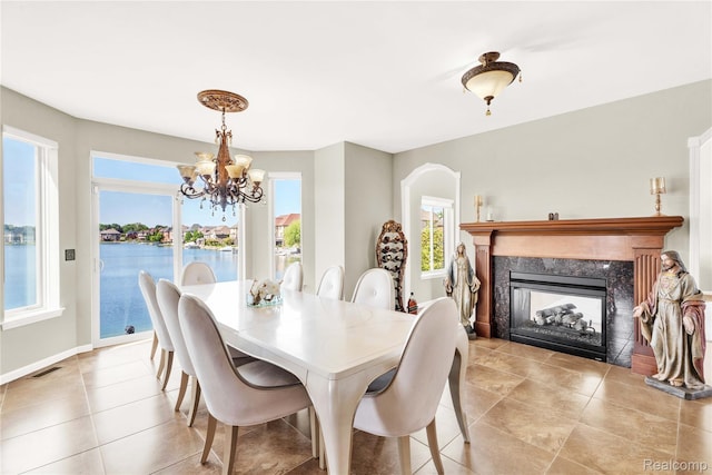 4303 S Lake Ln, Shelby Twp, MI 48316 - dining space with a chandelier, a fireplace, light tile patterned floors, and a water view