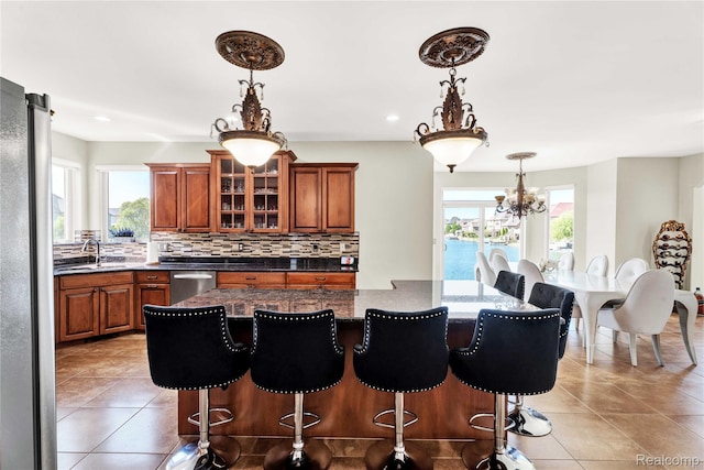4303 S Lake Ln, Shelby Twp, MI 48316 - kitchen with stainless steel appliances, a kitchen island, brown cabinetry, decorative backsplash, and recessed lighting