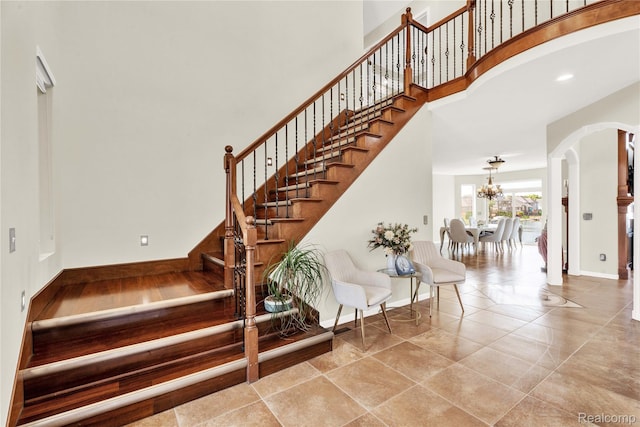 4303 S Lake Ln, Shelby Twp, MI 48316 - stairs featuring a chandelier, arched walkways, and a high ceiling
