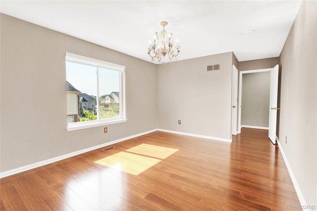 4303 S Lake Ln, Shelby Twp, MI 48316 - spare room with a chandelier and wood finished floors