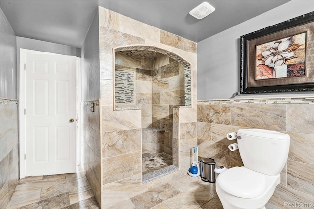 4303 S Lake Ln, Shelby Twp, MI 48316 - bathroom featuring tile walls, a walk in shower, and a wainscoted wall