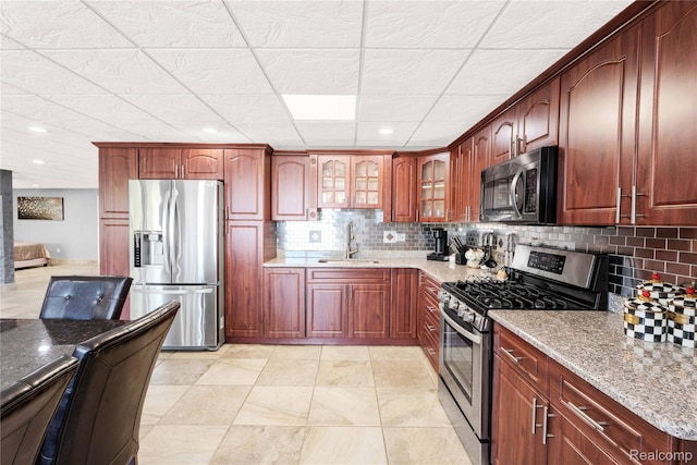 4303 S Lake Ln, Shelby Twp, MI 48316 - kitchen featuring stainless steel appliances, light stone countertops, tasteful backsplash, glass insert cabinets, and a paneled ceiling