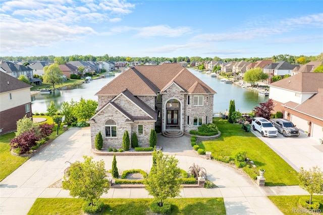4303 S Lake Ln, Shelby Twp, MI 48316 - french country home with stone siding, concrete driveway, a residential view, and a water view