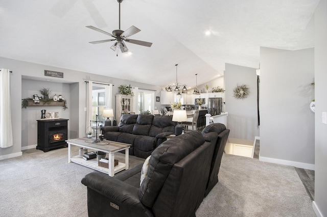 9733 E O Ave, Kalamazoo, MI 49048 - living area featuring lofted ceiling, light carpet, ceiling fan, a warm lit fireplace, and a chandelier