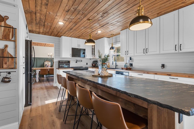 13451 S Waldron Rd, Waldron, MI 49288 - kitchen featuring black microwave, wooden ceiling, white cabinetry, light wood-type flooring, and pendant lighting