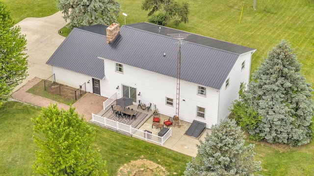 13451 S Waldron Rd, Waldron, MI 49288 - rear view of house with a chimney, a wooden deck, outdoor dining space, a patio, and a metal roof