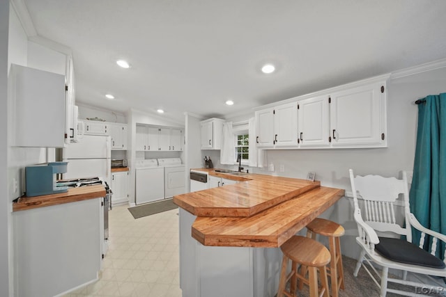 5390 Parkwood Ct, Manitou Beach, MI 49253 - kitchen featuring separate washer and dryer, range with gas cooktop, a peninsula, butcher block countertops, and white cabinets