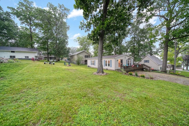 5390 Parkwood Ct, Manitou Beach, MI 49253 - view of green lawn featuring a wooden deck and gravel driveway
