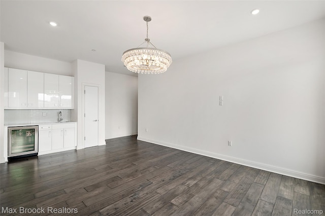 438 Selden St Unit 401, Detroit, MI 48201 - unfurnished living room featuring wine cooler, dark wood-type flooring, a chandelier, wet bar, and recessed lighting