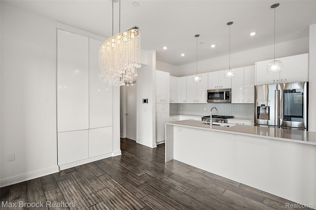 438 Selden St Unit 401, Detroit, MI 48201 - kitchen featuring stainless steel appliances, dark wood finished floors, light countertops, a chandelier, and white cabinetry