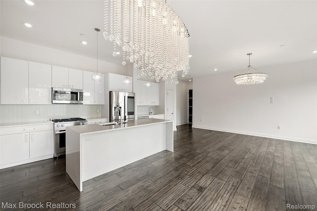 438 Selden St Unit 401, Detroit, MI 48201 - kitchen with stainless steel appliances, a chandelier, a center island with sink, white cabinetry, and light countertops