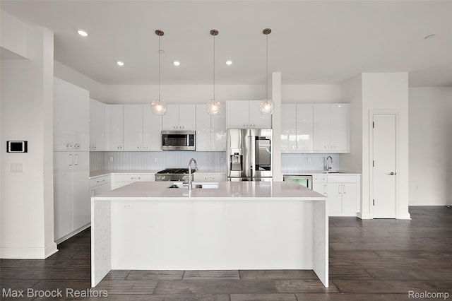 438 Selden St Unit 401, Detroit, MI 48201 - kitchen featuring appliances with stainless steel finishes, light countertops, an island with sink, decorative backsplash, and recessed lighting