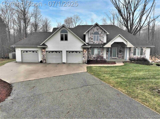 4695 Powell Dr, Mount Pleasant, MI 48858 - traditional-style house with driveway, stone siding, a front lawn, and roof with shingles