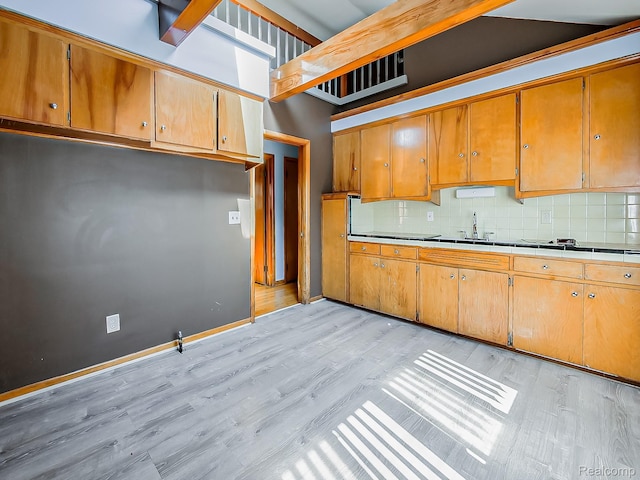 16039 Fordham St, Detroit, MI 48205 - kitchen featuring light wood-style floors, backsplash, brown cabinets, and tile counters